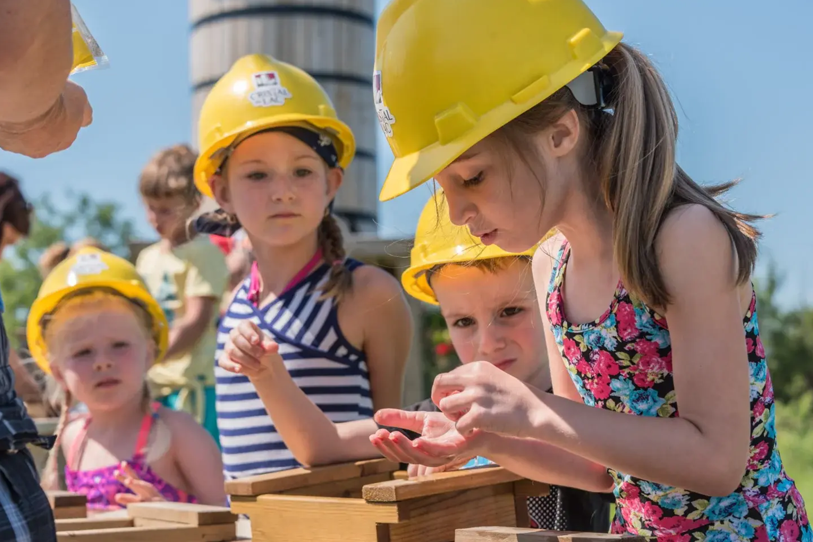 Famille et enfants s'amusant à tamiser du sable pour trouver des cristaux à l'activité de Prospection-Express dans la région de Saguenay Lac-Saint-Jean