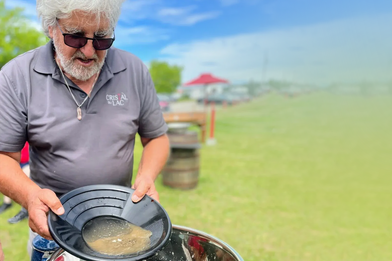 Un guide expert montrant la technique de la battée pour extraire de l'or au Centre d'Activités Minéralogiques de Metabetchouan